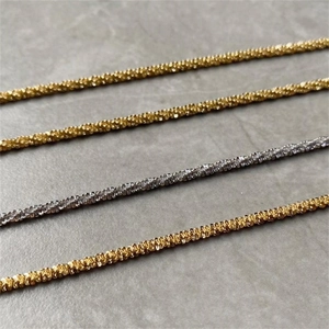 Macro shot of fine gold and silver stainless steel chains with diamond-cut textures