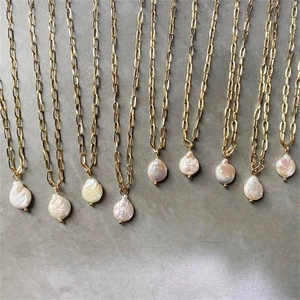 Detalle de collares de cadena de clip dorada con colgantes de perlas barrocas