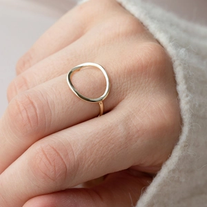 Close-up of a minimalist hollow geometric gold-plated stainless steel ring on a model