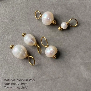 Dettaglio di cinque ciondoli in perle d'acqua dolce barocche con anelli in oro 14K