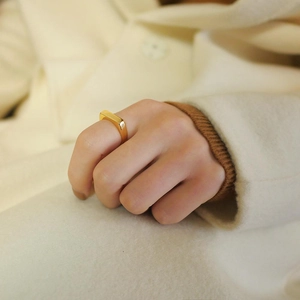 Gros plan d'une bague chevalière rectangulaire minimaliste en acier plaqué or 18 carats