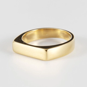 Détail macro d'une bague minimaliste plaquée or 18 carats avec surface plane polie