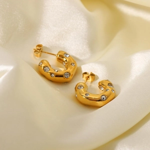 Textured 18K gold-plated C-shaped earrings with inlaid cubic zirconia on satin fabric