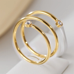 Dettaglio macro di anelli in acciaio inossidabile placcato oro 18K con zirconi lucidi