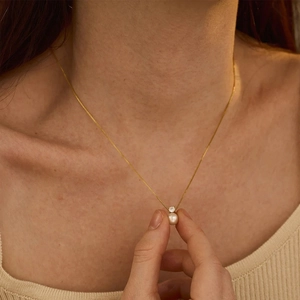Collana minimalista in acciaio inossidabile dorato con perla e zircone su modella