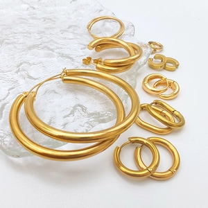 Collection of golden stainless steel hoop earrings in various sizes and shapes on white
