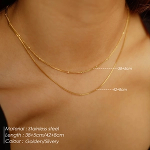 Detail of layered stainless steel bead and snake chain necklace set with size markings