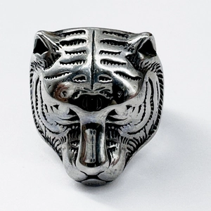 Detail of vintage tiger head ring in stainless steel with carved patterns and retro finish