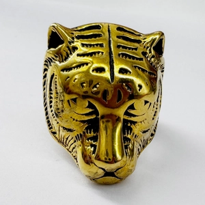 Detailed macro view of a golden stainless steel ring featuring a bold tiger head design