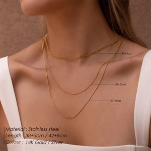 Layered gold stainless steel necklaces featuring Cuban, bead, and snake chain designs