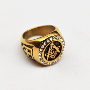 Macro view of gold Freemason ring with clear crystals and engraved side cross detail