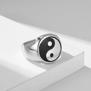 Detail shot of vintage stainless steel Tai Chi Yin Yang signet ring on a white pedestal