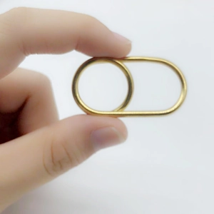 Close-up of golden dual-finger cross ring showing a minimalist geometric double loop design