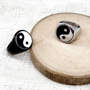 Close-up of black and silver stainless steel rings with classic Tai Chi Yin Yang symbol