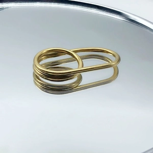 Macro shot of minimalist gold double finger cross ring with high gloss metallic reflection