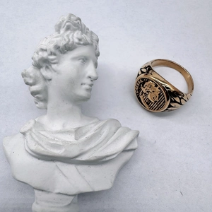 Detailed macro view of the gold Caesar signet ring with engraved Roman laurel leaf accents