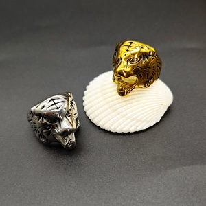 Detailed view of fierce gold tiger head ring on a white shell with polished metallic finish