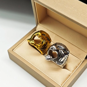 Detailed close-up of sculpted gold and silver tiger head rings in a premium gift box