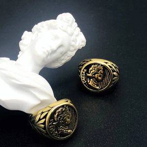 Detailed close-up of vintage golden Roman Caesar relief ring with laurel leaf patterns