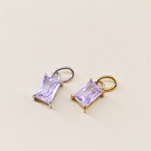 Close-up of radiant cut purple zircon charms with 18K gold and silver plated settings