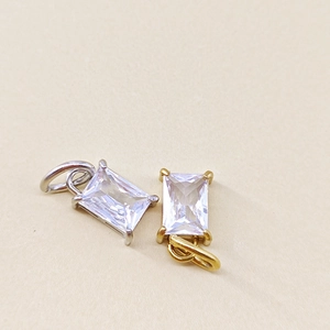 Detailed close-up of rectangle-cut birthstone pendants with gold and silver claw settings