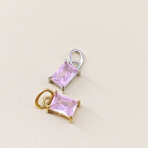 Detail of rectangular pink zircon charms with gold and silver plated settings for DIY jewelry