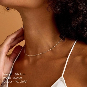 Minimalist 14K gold plated necklace with delicate white crystal beads shown on model