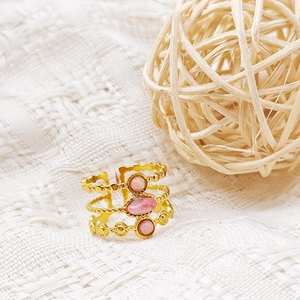 Detalle del anillo ajustable de tres capas bañado en oro de 18K con gemas rosas en punto