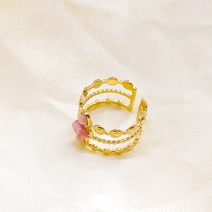 Detalle del anillo de tres capas chapado en oro de 18K con detalles de rubí rosa