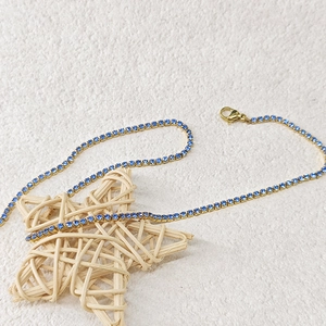 Détail du collier tennis en zircon bleu avec base dorée et fermoir mousqueton robuste