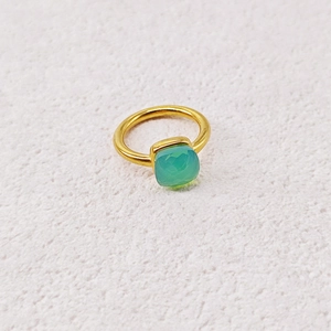 Macro detail of minimalist gold ring with square faceted green zircon gemstone