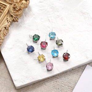 Detailed view of colorful 6mm round zircon pendants with silver claw settings on stone