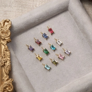 Detailed display of twelve colorful rectangular zircon pendants in gold-plated settings