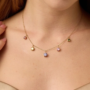 Minimalist gold chain necklace with five colorful round zircon pendants worn by a model