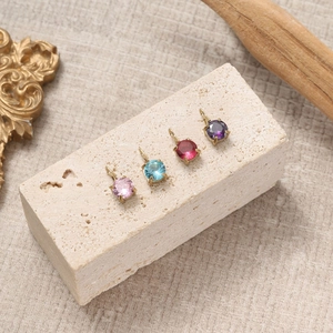 Macro view of round zircon charms in four colors with gold plated prong settings for DIY jewelry