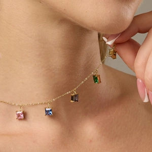 Dettaglio della collana con ciondolo in zircone colorato sul collo con catena dorata