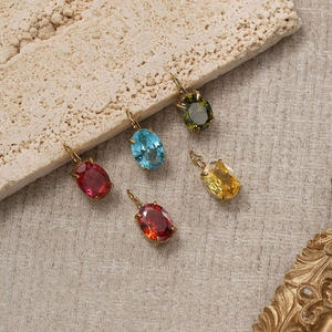 Pendentifs ovales pierre de naissance en serti doré sur fond de pierre naturelle