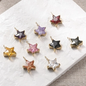 Détail macro de pendentifs étoiles en acier inoxydable coloré avec pierres de zircon