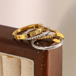Detailed close-up of 18K gold and silver stacked rings featuring star and pin designs