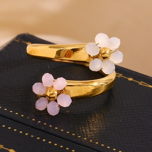 Detailed macro view of 18K gold plated spiral ring featuring pink and white flower charms