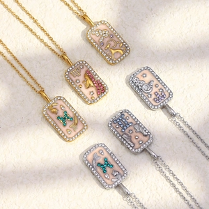 Détail de pendentifs zodiaque carrés plaqués or 18K avec cristaux colorés et zircons