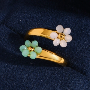 Detail of 18K gold-plated open ring featuring green and white beaded flowers on velvet