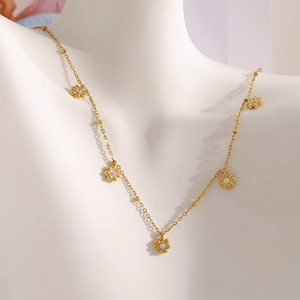 Detail einer 18K vergoldeten Blumen-Halskette mit Glitzersteinen am Modell