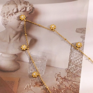 Detailansicht der 18K vergoldeten Blumenkette mit Zirkonia-Mitte und Perlenkette