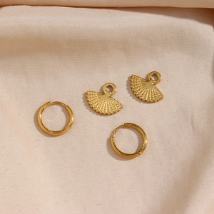 Macro shot of gold fan-shaped charms with radial texture and matching hoop earrings