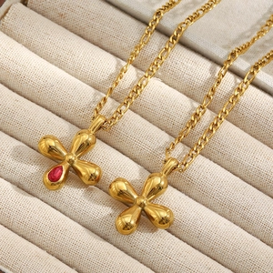 Dettaglio delle collane placcate in oro 18 carati con zircone rosso e ciondoli floreali