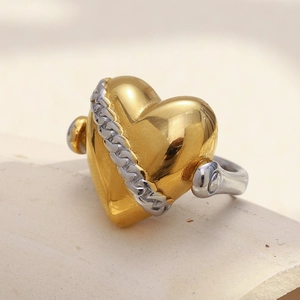 Foto macro de anillo de corazón en oro de 18K con detalle de cadena de plata pulida
