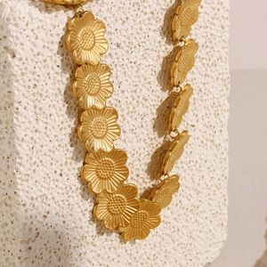 Détail du collier pendentif marguerite en or 18 carats mat avec texture florale