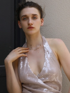 Detalle de collar chapado en oro de 18K con colgantes de corazón en una modelo mujer