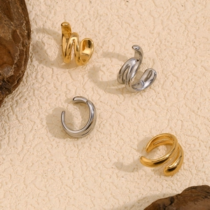 Set of four gold and silver double-layered spiral ear cuffs on a textured background